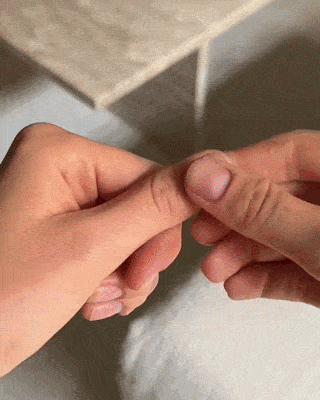 Placing a glue tab on a natural nail, then pressing a dafies tip on top